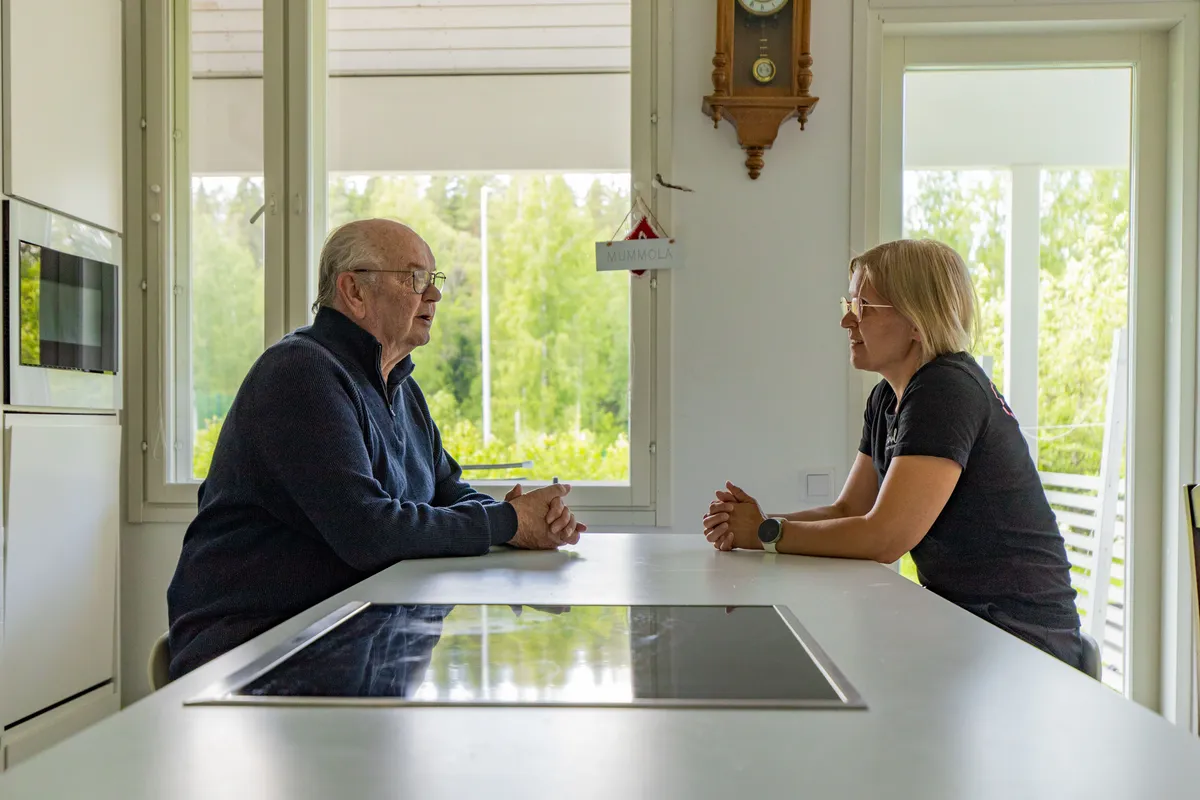 Sairaanhoitaja ja asiakas keskustelevat terveydentilasta